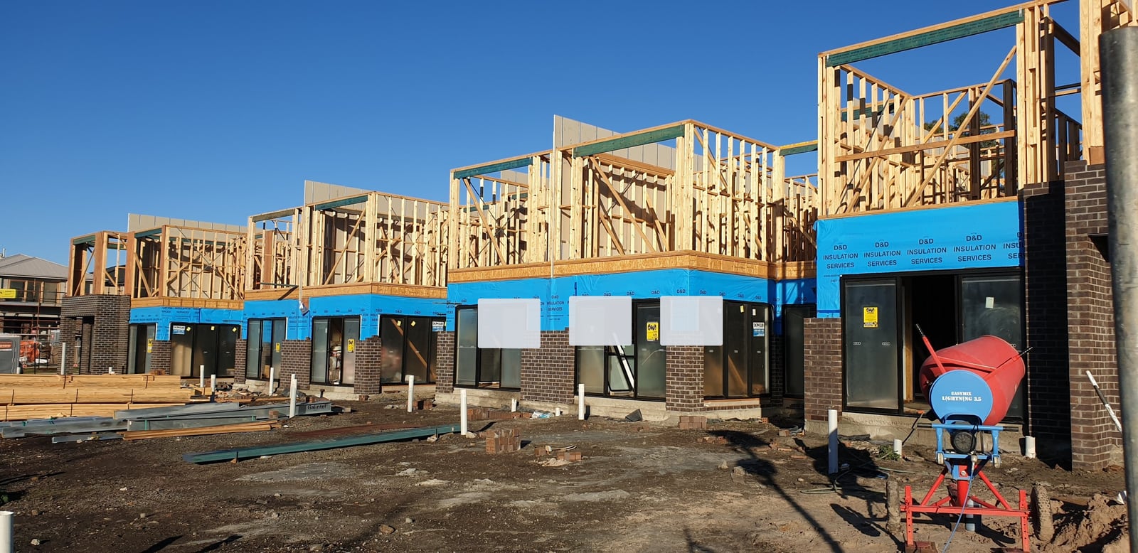Black-and-white timber-framed townhouse construction used to represent specialised construction funding and progress claim reports.